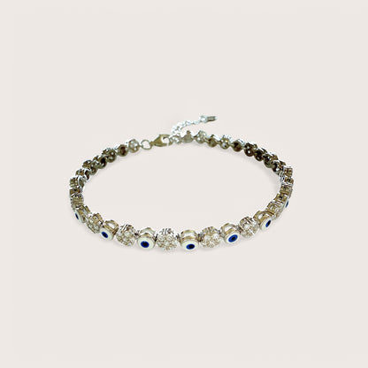 An adjustable sterling silver bracelet featuring a dark blue evil eye and clusters of clear cubic zirconia stones.