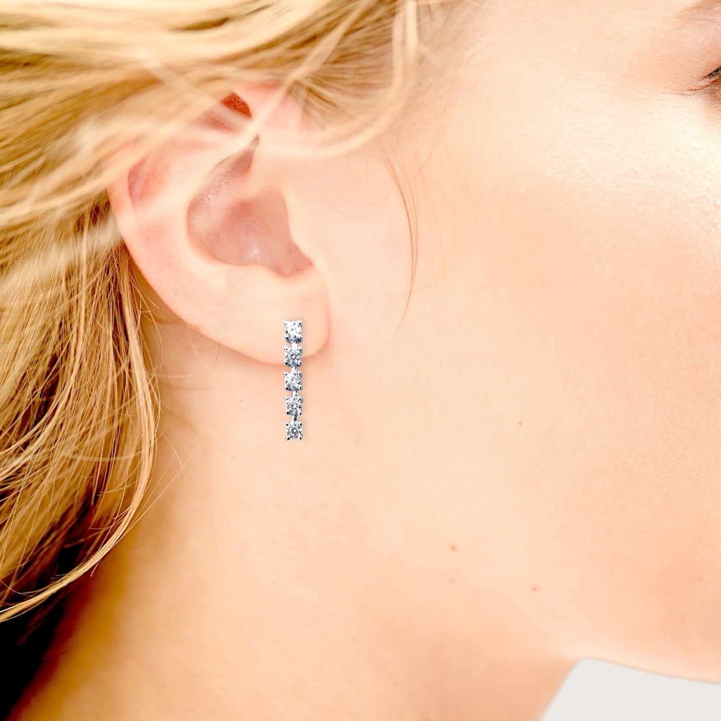 Model wearing 18mm silver vertical bar drop studs in first piercing.
