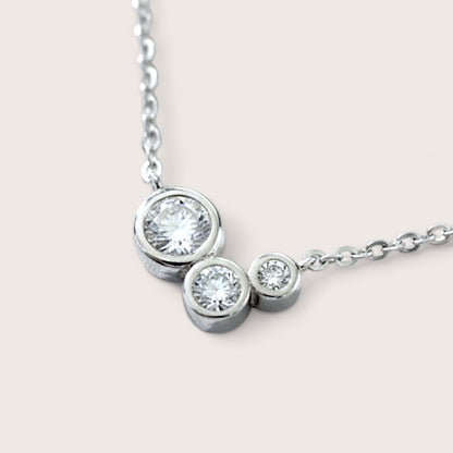 Close-up of three-stone Moissanite cluster necklace showing the high-refractive 'fire' and brilliance of the stones