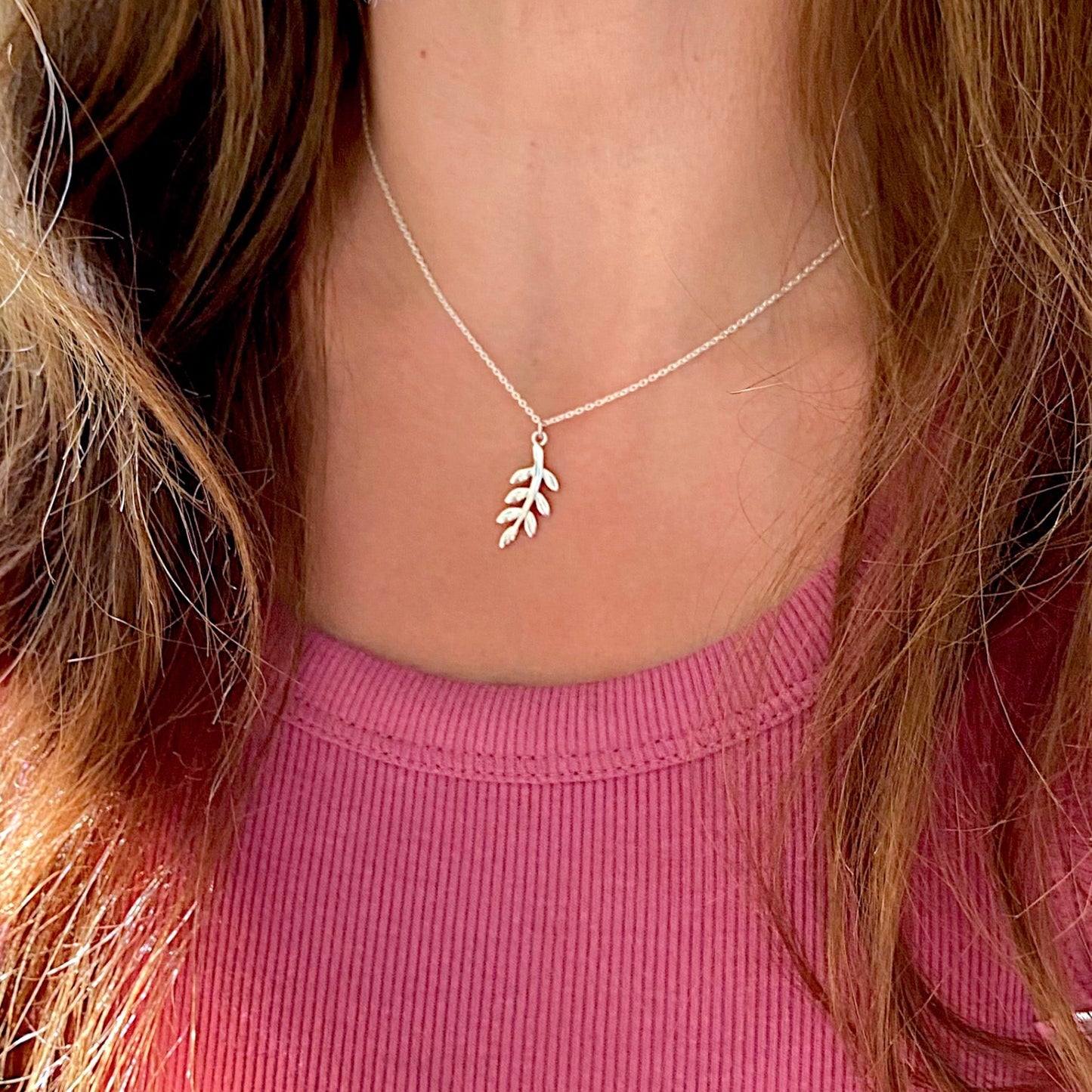 A model wearing a solid 925 sterling silver olive branch necklace