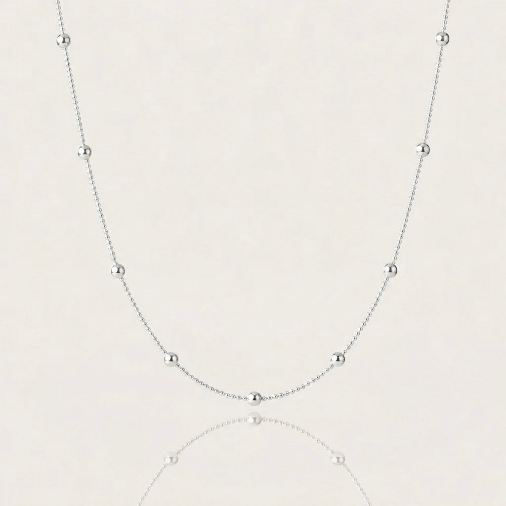Close-up shot of 925 sterling silver satellite station necklace a plain background, showcasing the high-polish 3mm round beads on 1mm smooth ball chain.
