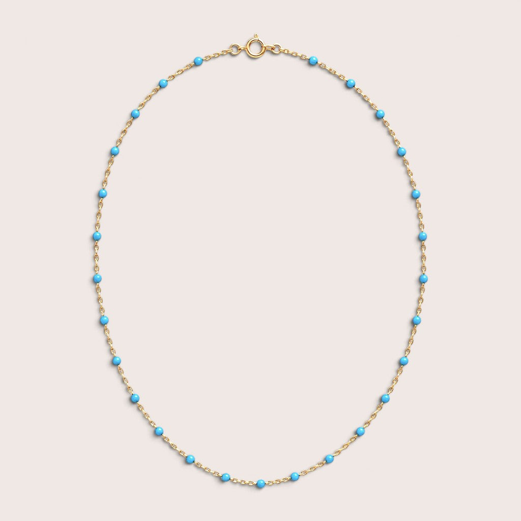 Turquoise teal enamel station beads spaced along a gold-filled necklace