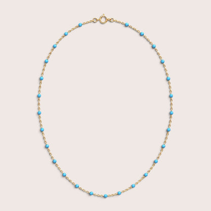 Turquoise teal enamel station beads spaced along a gold-filled necklace