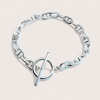 Solid Italian sterling silver anchor link bracelet with a toggle clasp displayed flat on a clean surface by Ashley Nicole Jewelry