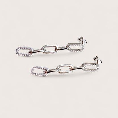 Pair of cz silver chain-link earrings on a light gray background