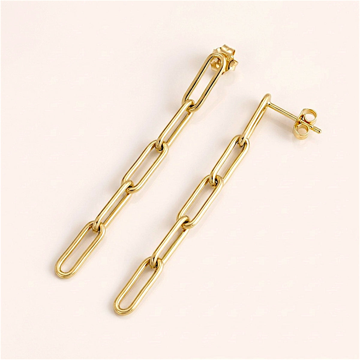 Gold-filled five-link paperclip earring pair arranged diagonally, showing the interlocking links, stud posts, and butterfly backs.
