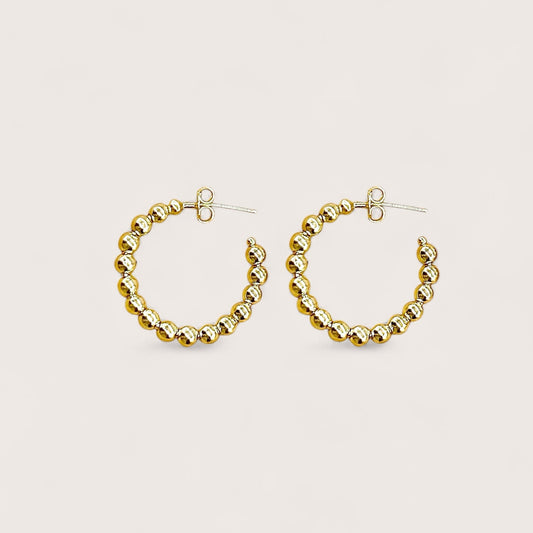 A pair of 25mm dainty 18K gold plated beaded hoop earrings showcasing a continuous row of polished gold beads on a clean white background.