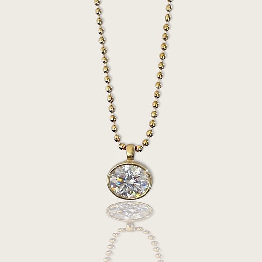 18K gold PVD stainless steel horizontal oval bezel-set cubic zirconia pendant necklace on a 2mm beaded ball chain by Ashley Nicole Jewelry, front view with reflection