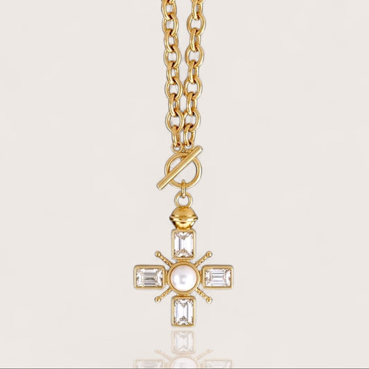 Front-facing studio view of the gold Maltese cross front toggle necklace featuring a heavy cable chain, emerald-cut crystals, and a central pearl accent.