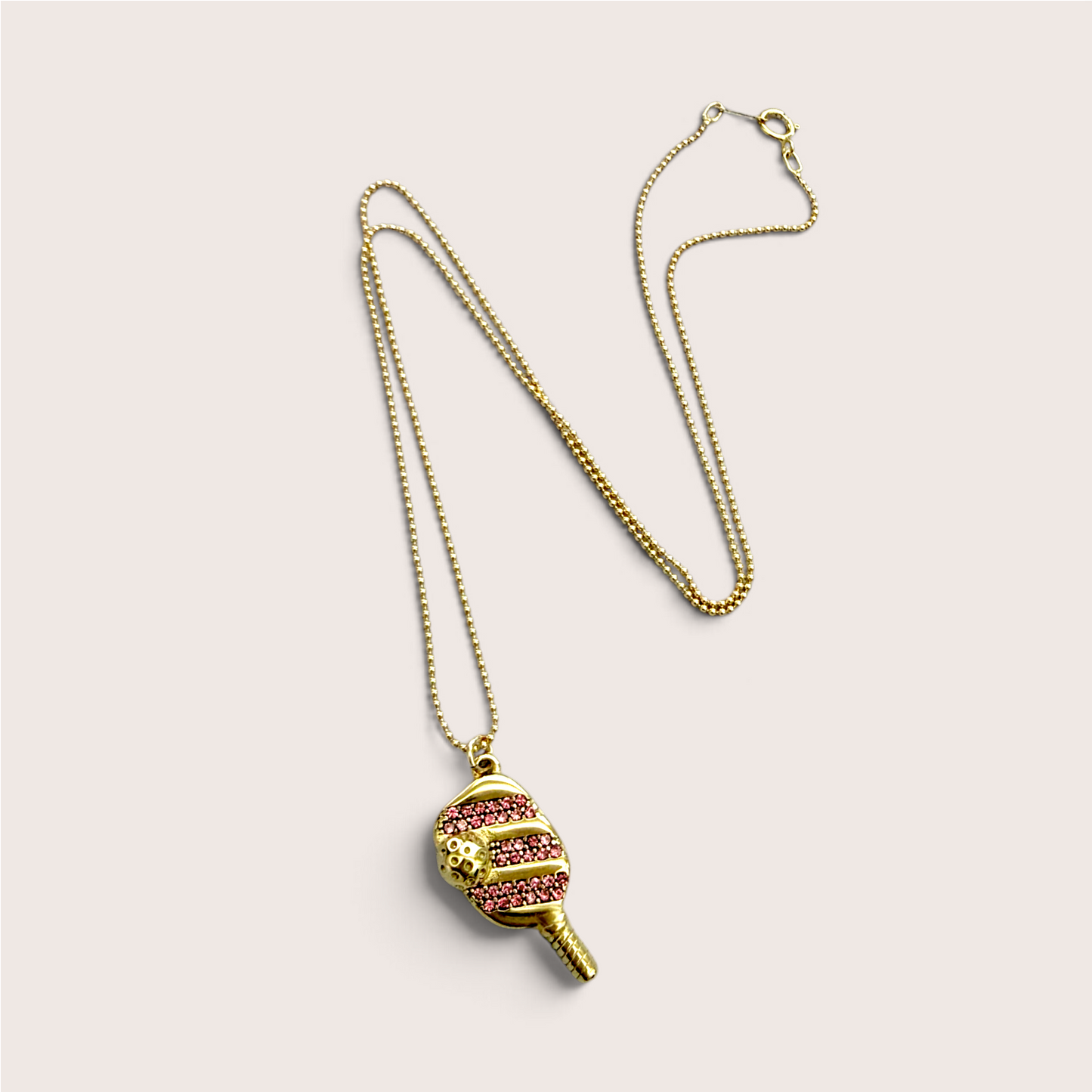 Full-length view of the gold beaded ball chain and pickleball paddle pendant laid out flat