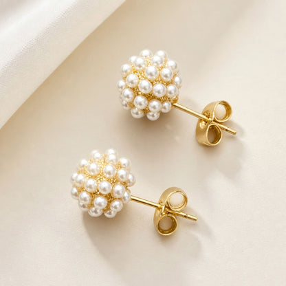 Two rounded pearl cluster earrings arranged diagonally, showing the ivory pearls, gold settings, straight posts, and butterfly backs.