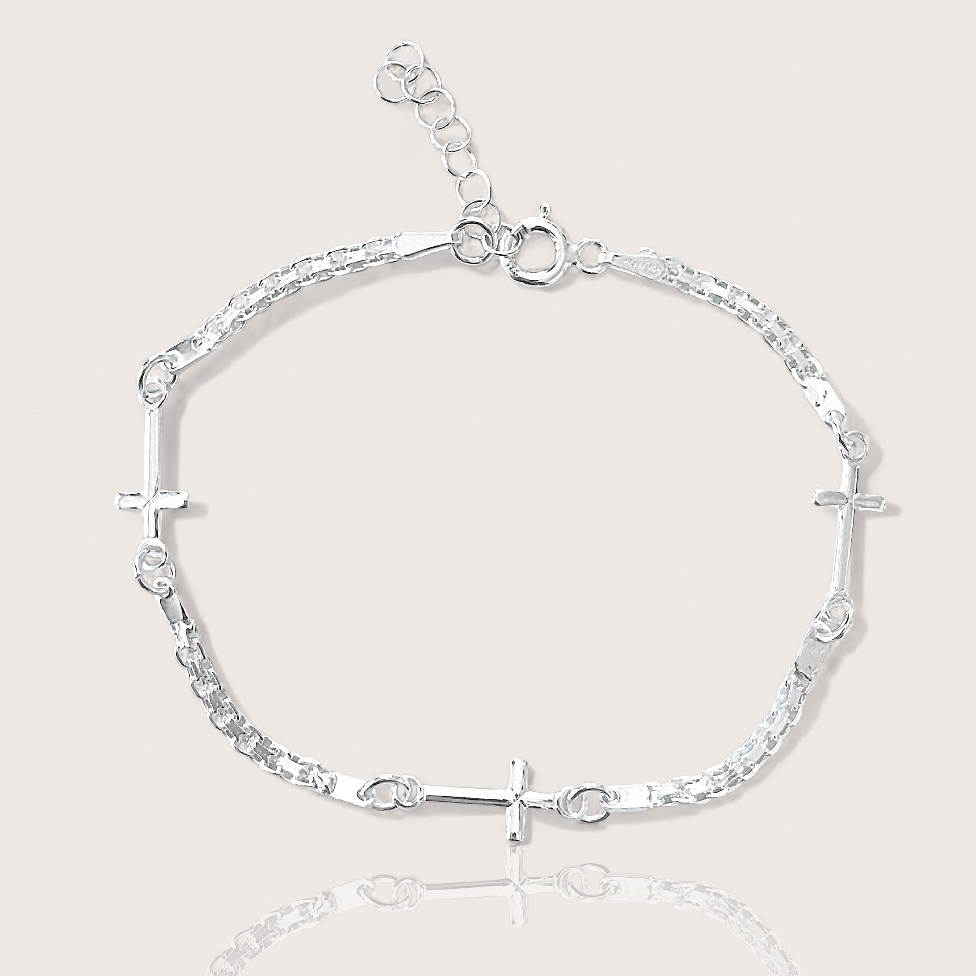 Adjustable Sterling silver linked crosses bracelet on plain background