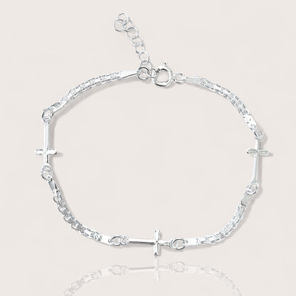 Adjustable Sterling silver linked crosses bracelet on plain background