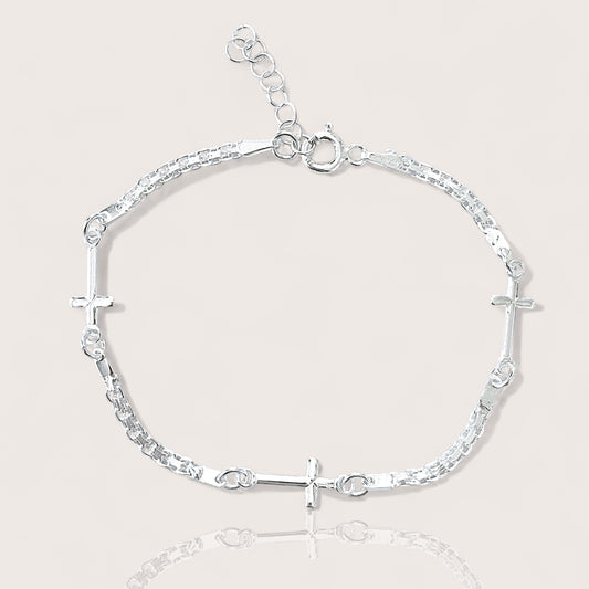 Adjustable Sterling silver linked crosses bracelet on plain background