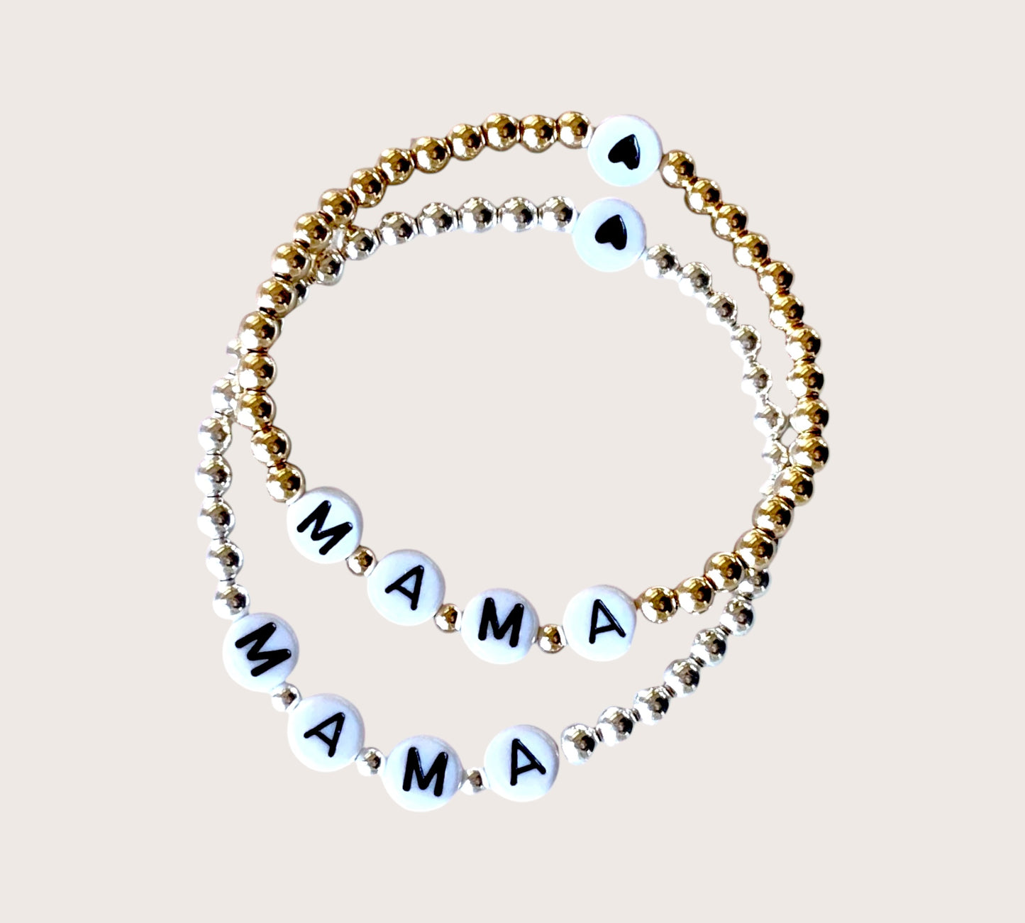 Close up of Mama jewelry in gold and silver