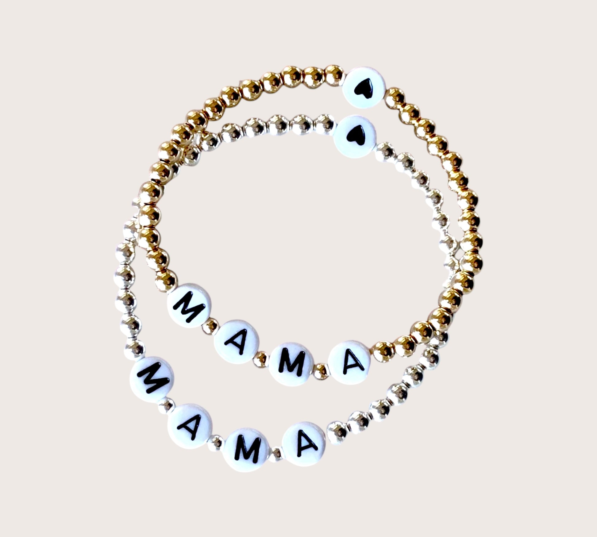 Close up of Mama jewelry in gold and silver