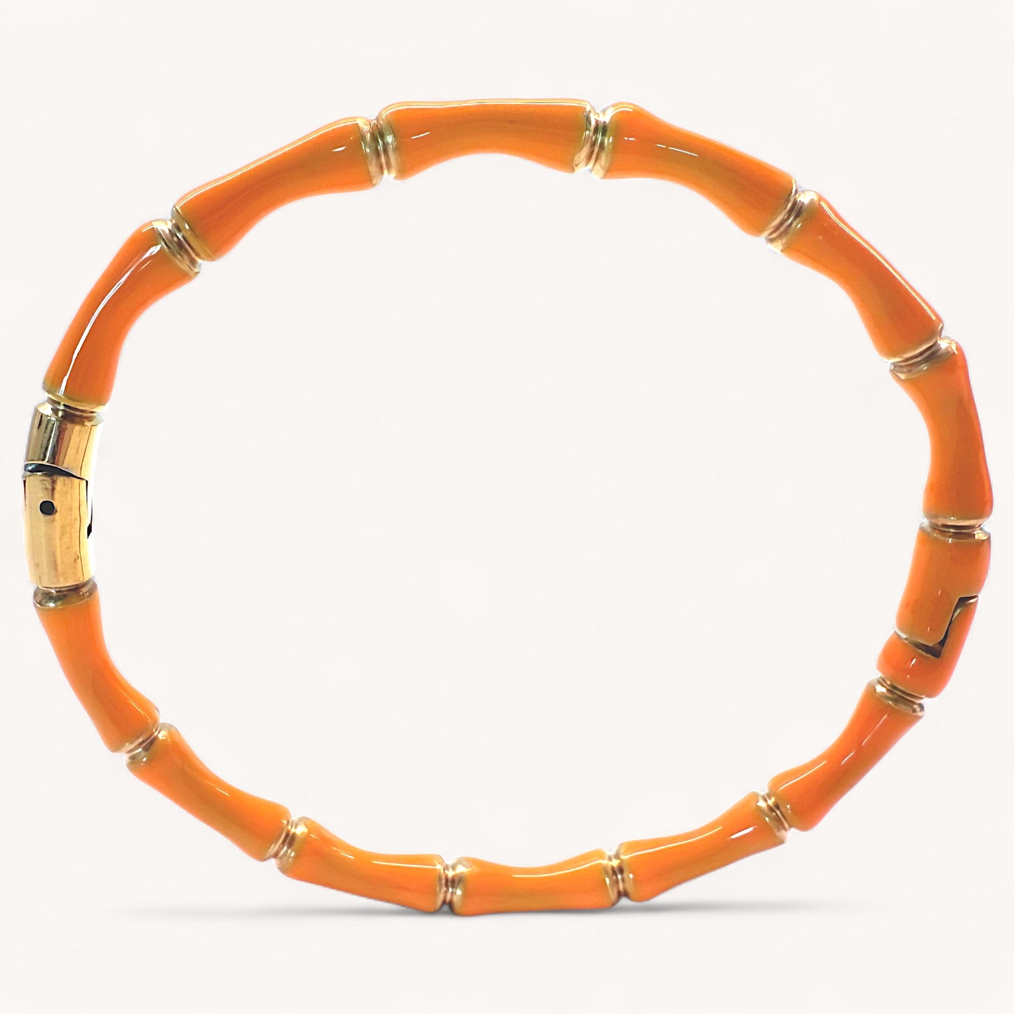 Close up image of 18k gold plated stainless steel bamboo bangle bracelets with high gloss Orange tangerine color enamel finish showing details of the geometric wood inspired nodes by Ashley Nicole Jewelry.