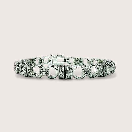 Silver bracelet with various links on a light gray background