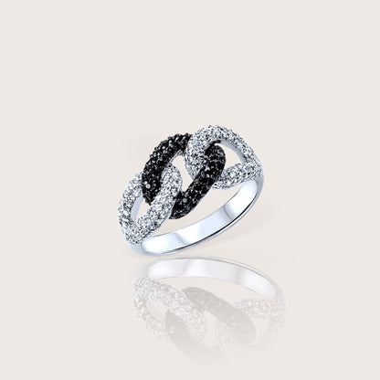 A silver ring with black and clear cubic zirconia stones set in a twisted band design.