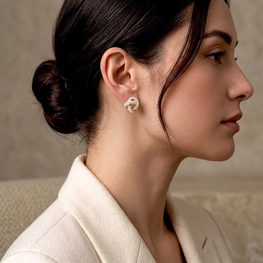 Lifestyle view of the gold pearl cluster love knot studs styled on a model to show their elegant, wedding-ready scale.