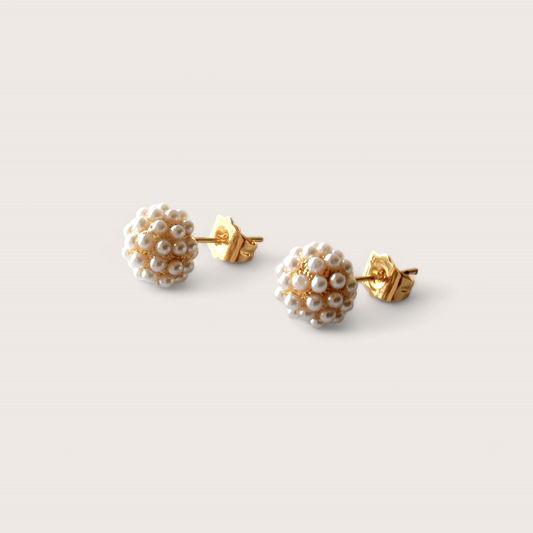 1mm Pave Pearl Cluster Earrings. Delicately dotted with white ivory pearls, this modern take on a classic design will add a touch of sophistication to any outfit. Exude luxury and style with these timeless earrings.