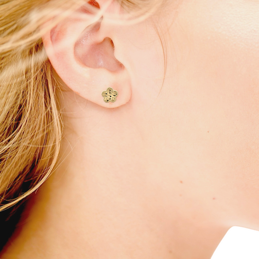 Model wearing out dainty 14k gold clover flower earrings