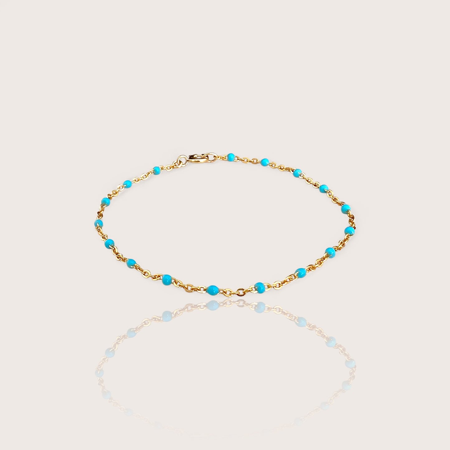 This high-quality Vibrant Turquoise Gold Chain Bracelet is made with 1.8mm delicate enamel beads and strong 14K gold fill. It's perfect for everyday wear, and can even be worn in the shower without losing its shine or color. This one-of-a-kind bracelet is handmade in sunny Laguna Beach, CA and comes in customizable sizes for everyone from newborns to adults. It's a fun and functional gift suitable for any occasion!
