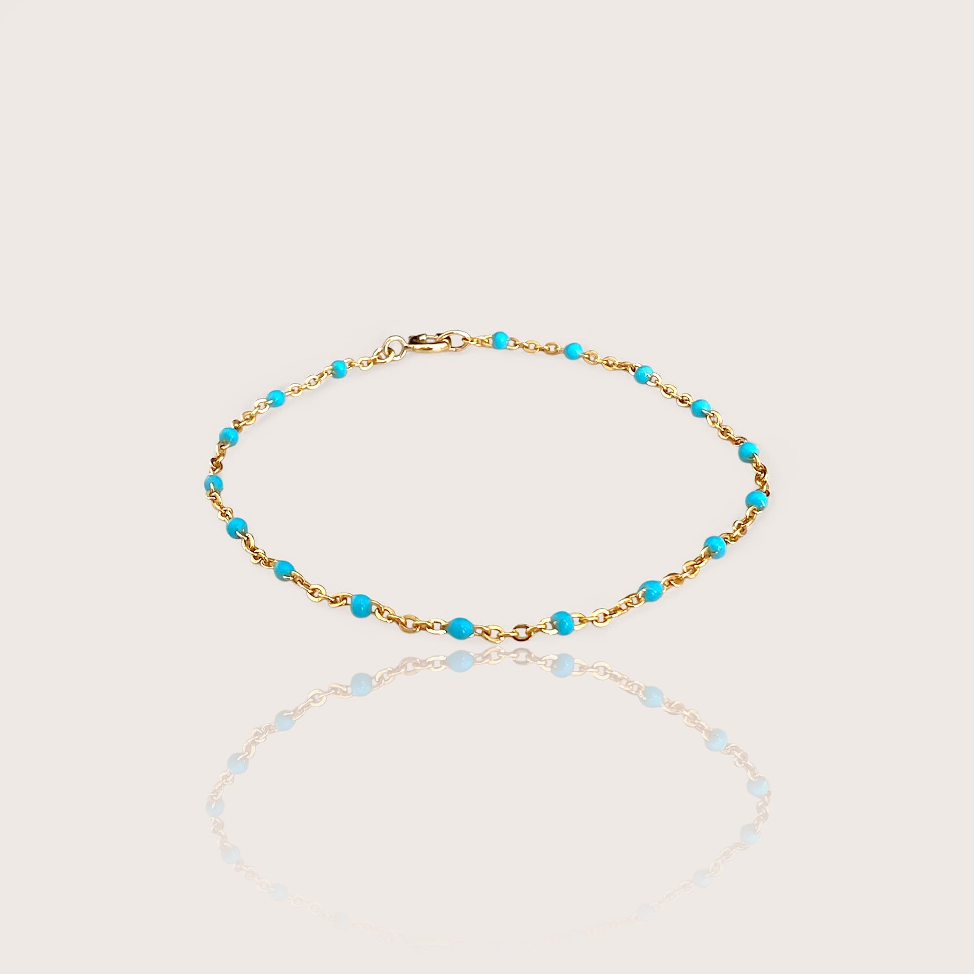 This high-quality Vibrant Turquoise Gold Chain Bracelet is made with 1.8mm delicate enamel beads and strong 14K gold fill. It's perfect for everyday wear, and can even be worn in the shower without losing its shine or color. This one-of-a-kind bracelet is handmade in sunny Laguna Beach, CA and comes in customizable sizes for everyone from newborns to adults. It's a fun and functional gift suitable for any occasion!