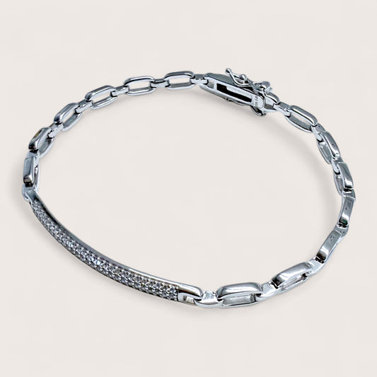 Close up image of Rhodium Sterling Silver Diamond Pave Bar Paperclip Bracelet with embedded stones on a light gray background