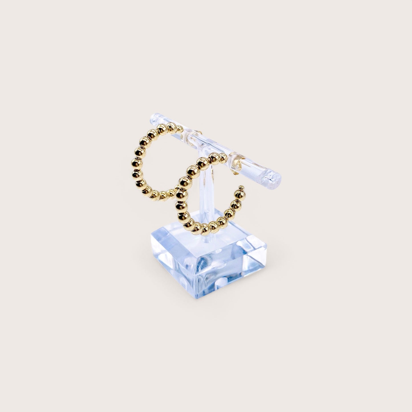 Close-up highlighting the uniform 4mm high-shine gold beads and the smooth, secure push-back post closure.