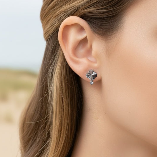 Ashley Nicole Jewelry sterling silver fluted four leaf clover stud earrings with a tiny cz accent drop on model ear