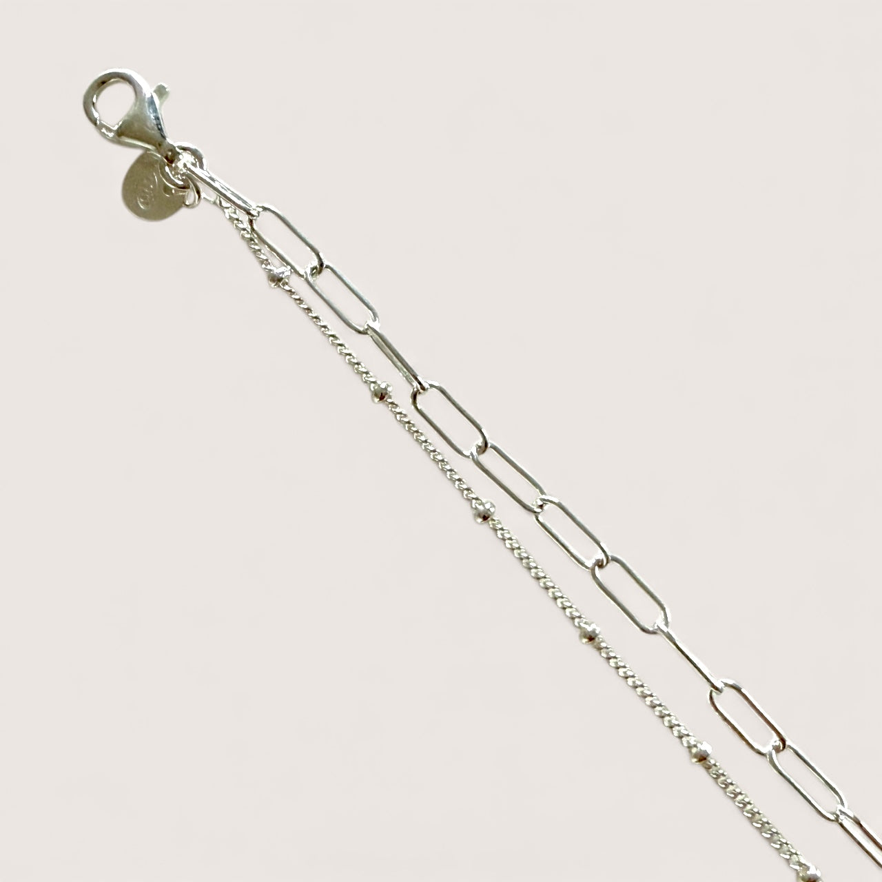 Close up of dainty sterling silver bracelet with lobster clasp closure