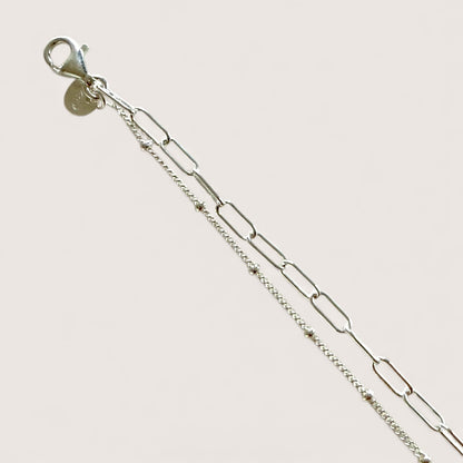 Close up of dainty sterling silver bracelet with lobster clasp closure