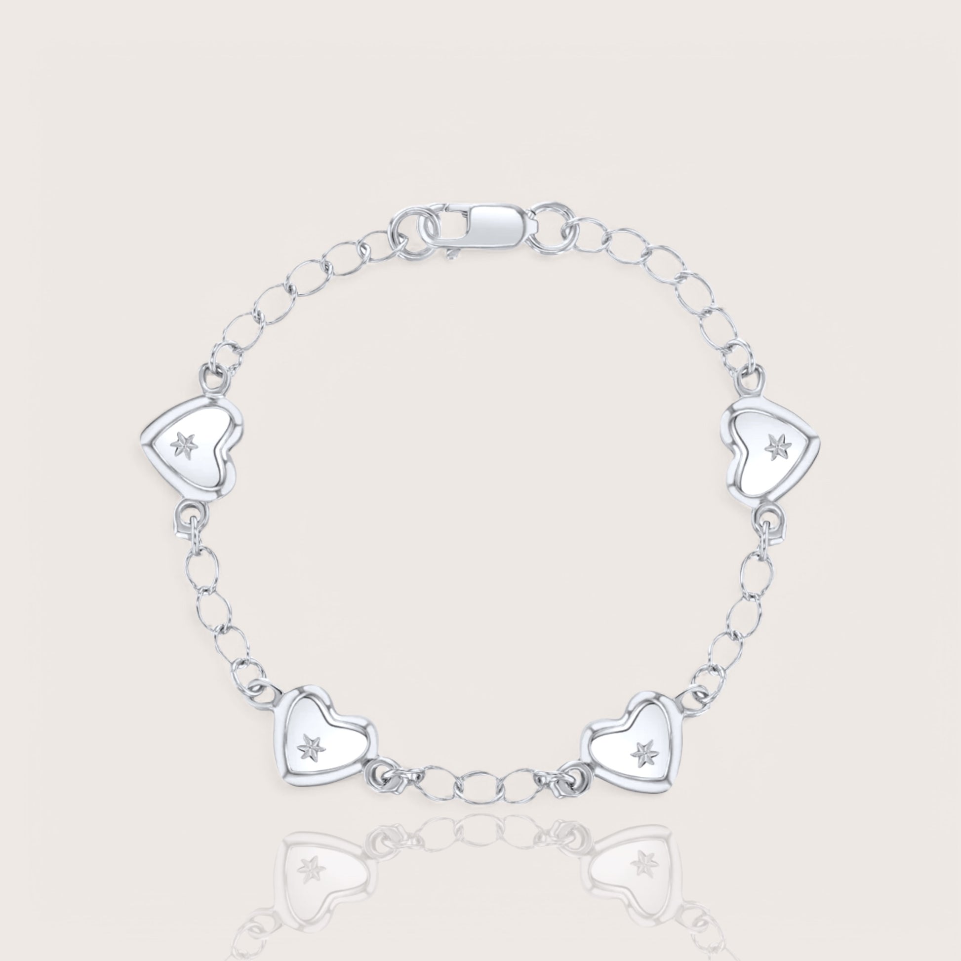 A silver charm bracelet for babies or toddlers featuring a chain design with five heart charms, each adorned with a star embellishment.