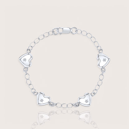 A silver charm bracelet for babies or toddlers featuring a chain design with five heart charms, each adorned with a star embellishment.