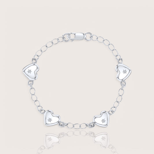 A silver charm bracelet for babies or toddlers featuring a chain design with five heart charms, each adorned with a star embellishment.