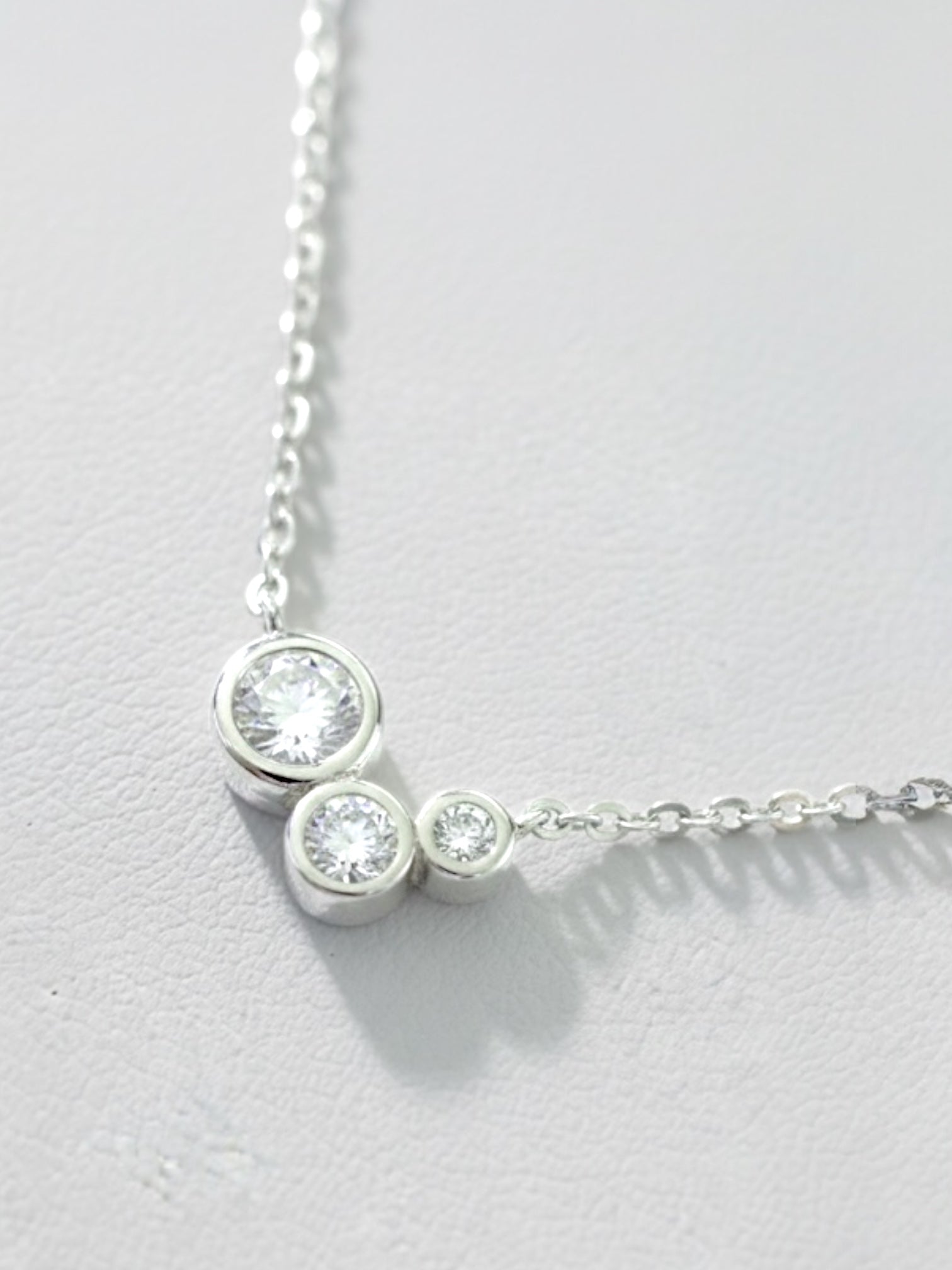 Close-up of bezel-set round moissanite cluster pendant