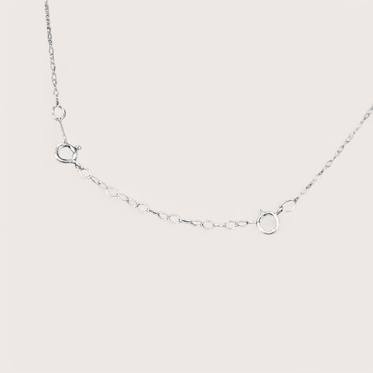 Close-up detail of dainty silver cable chain links and secure attachments with a bright mirror silver finish. Displays how to attach to necklace to make it longer.