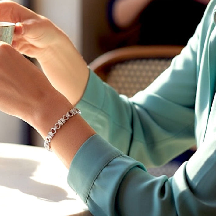 925 Sterling  Silver Pave CZ U Link chain bracelet on a light gray  Person holding a cup of coffee in a cozy indoor setting