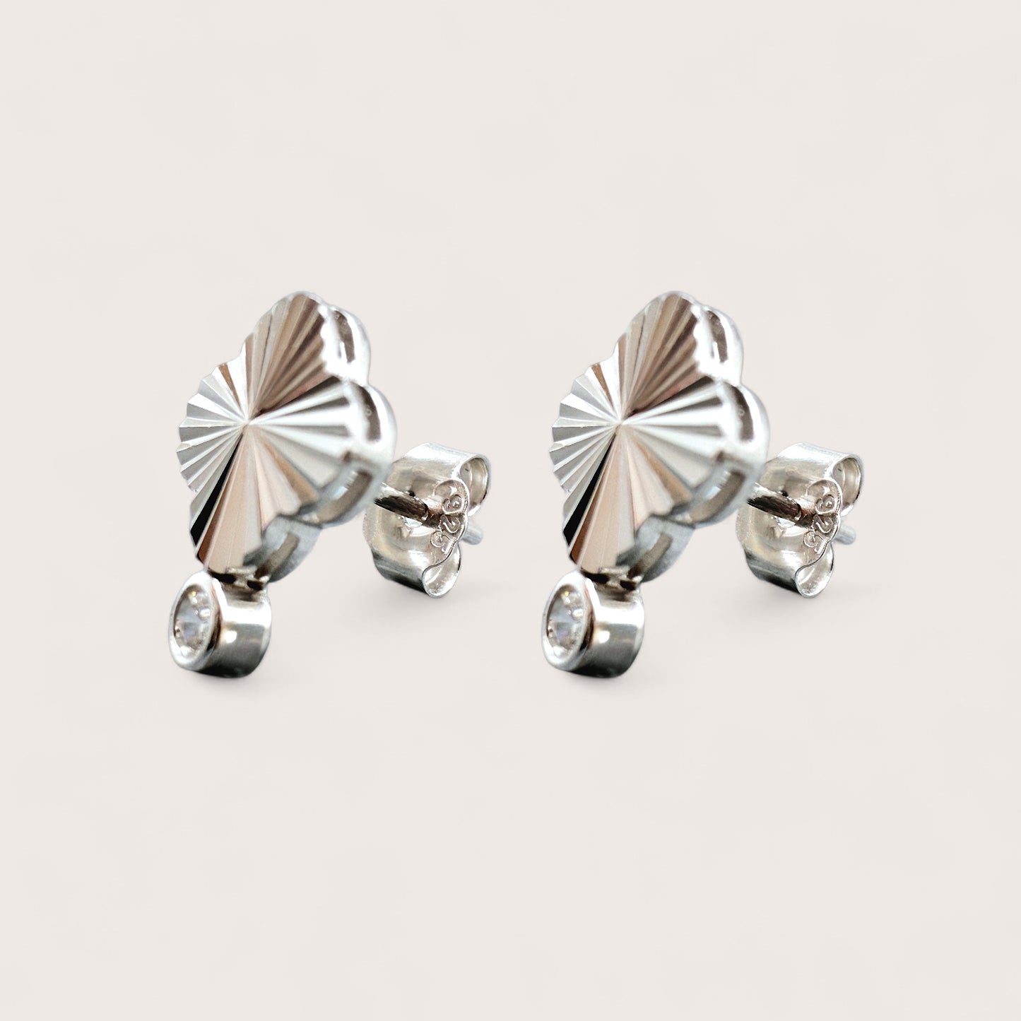 Pair of silver earrings with a diamond cut pattern geometric 4-leaf clover design and a sparkling solitaire cubic zirconia gemstone.