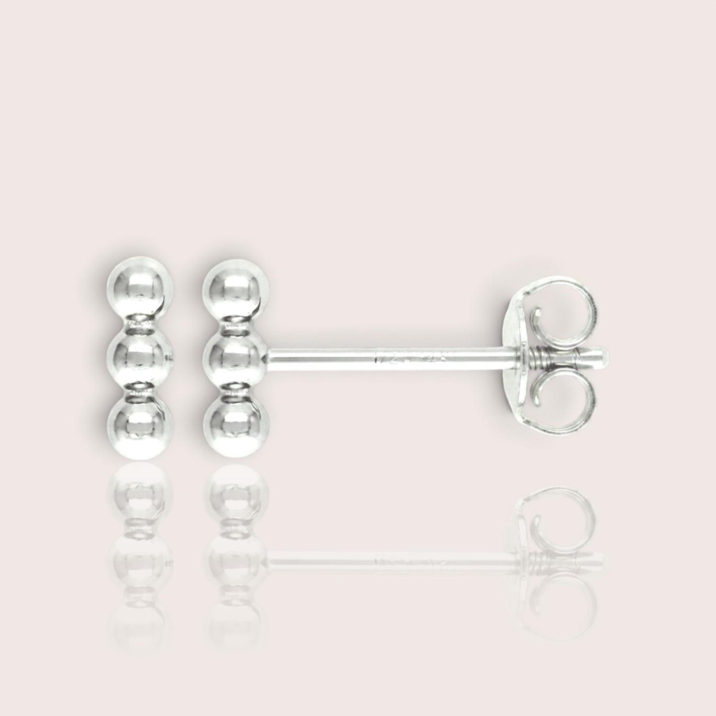 Close up of triple bead vertical bar stud earrings available in solid sterling silver. Waterproof, tarnish-free, and hypoallergenic.