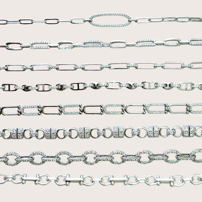 Collection of silver chain bracelets  on a light gray background