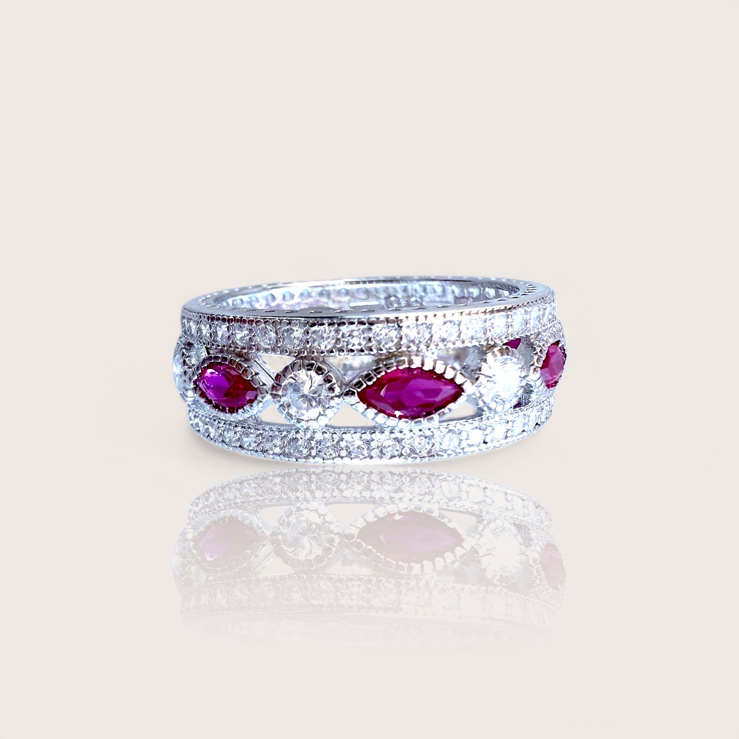 A sterling silver eternity ring with marquise and round-cut pink sapphire CZ stones set in a rhodium-plated band.