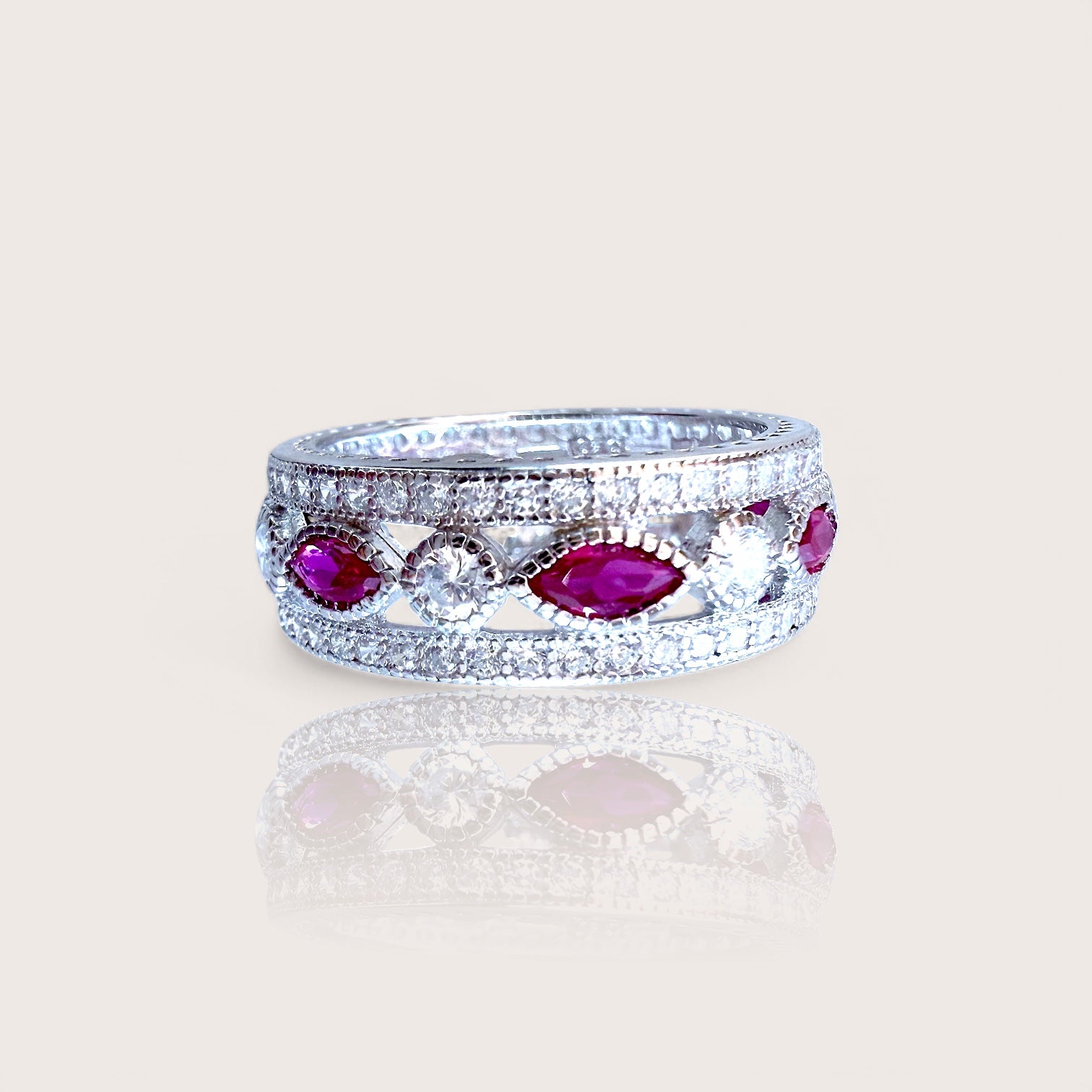 A sterling silver eternity ring with marquise and round-cut pink sapphire CZ stones set in a rhodium-plated band.