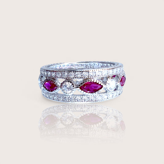 A sterling silver eternity ring with marquise and round-cut pink sapphire CZ stones set in a rhodium-plated band.