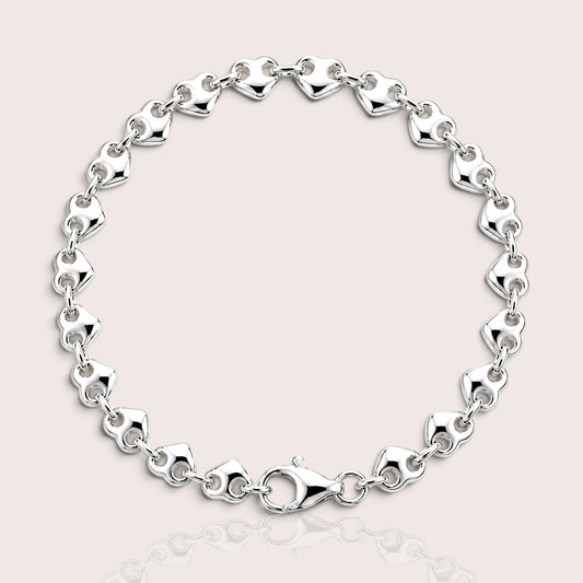 Polished silver puffed heart link bracelet arranged in a circle with the lobster clasp visible.