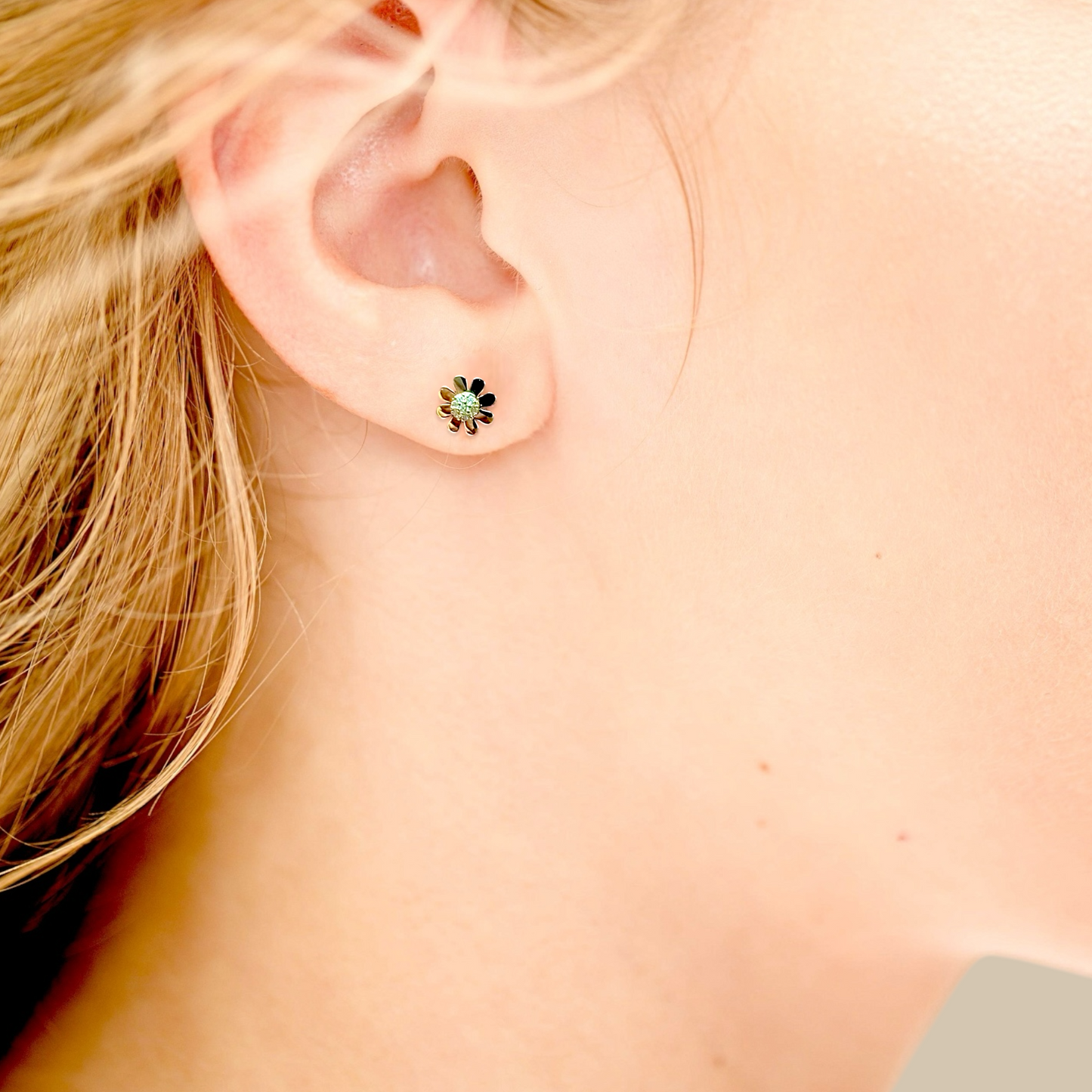 Model wearing Dainty 14K Solid Gold Daisy Flower Earrings, 7mm with secure screw back closure, sparkling lab diamonds for the perfect twinkle. 