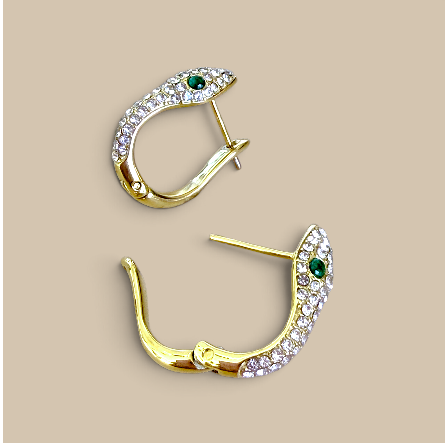 A top-down flat lay perspective of the two 18K gold PVD-finished snake huggie earrings, showing the full curved silhouette and post-back closure mechanism.