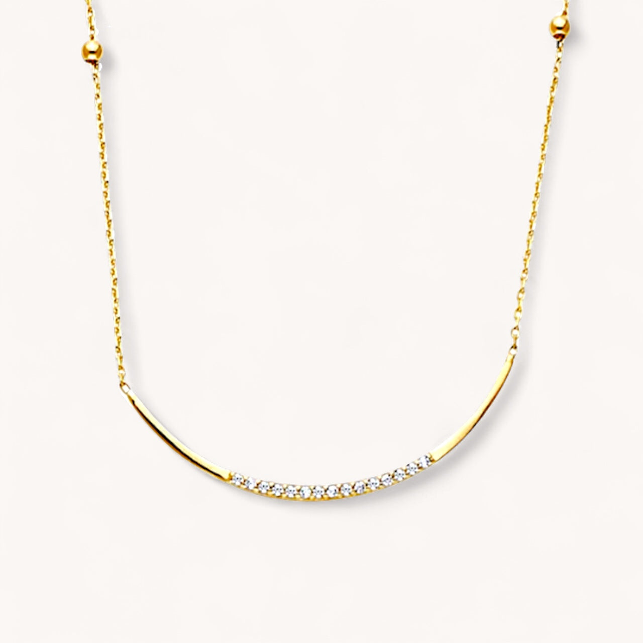 Gold necklace with small diamonds on a white background