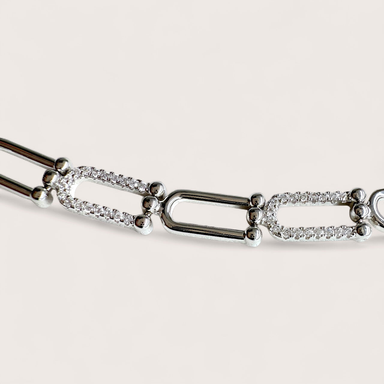 Close up of the U link Pave CZ Silver bracelet with diamond accents on a light gray background
